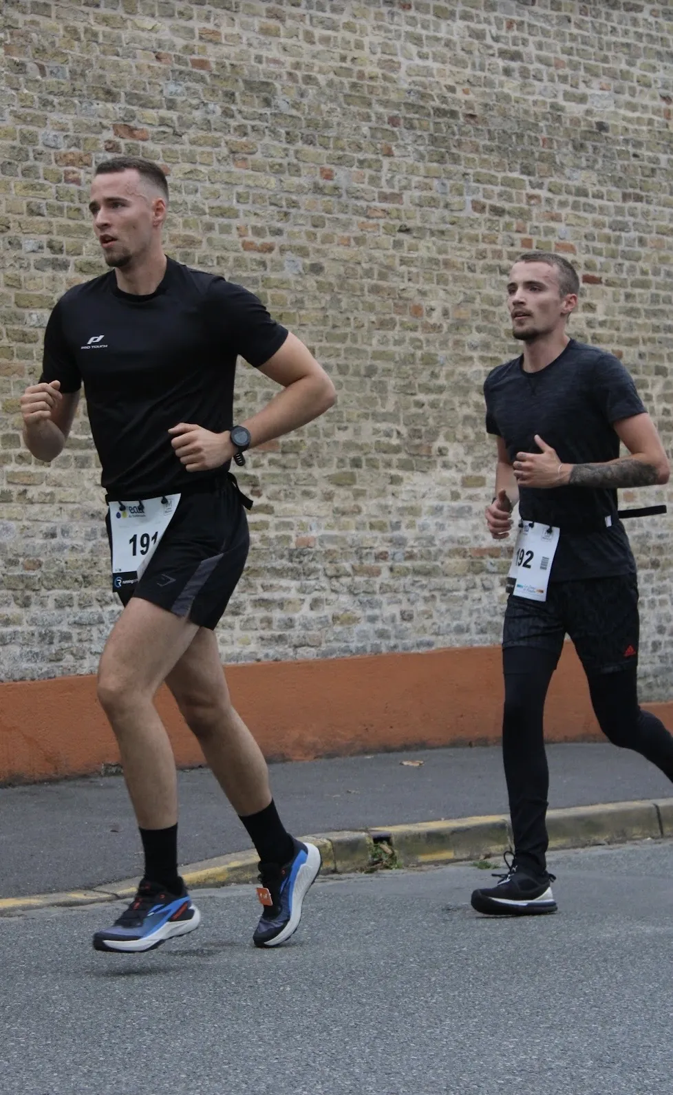 Le coach ouvrant la voie à Jules, son élève, pendant les 10 km de la Course Rouge Flamande à Bergues en 2025