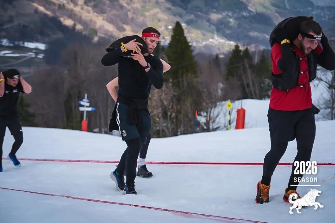 Le coach portant un sac lesté dans la neige lors d'une Spartan Race