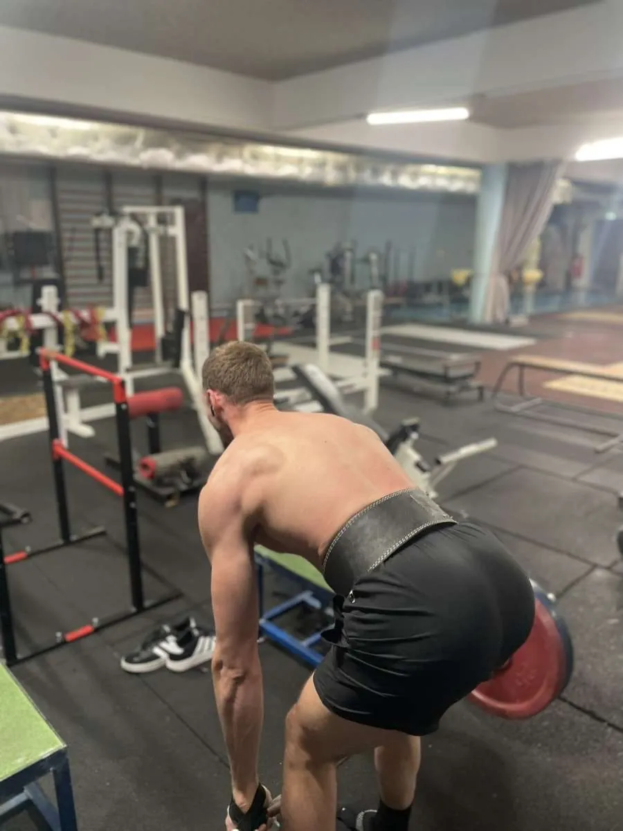 Le coach en soulevé de terre en salle de musculation