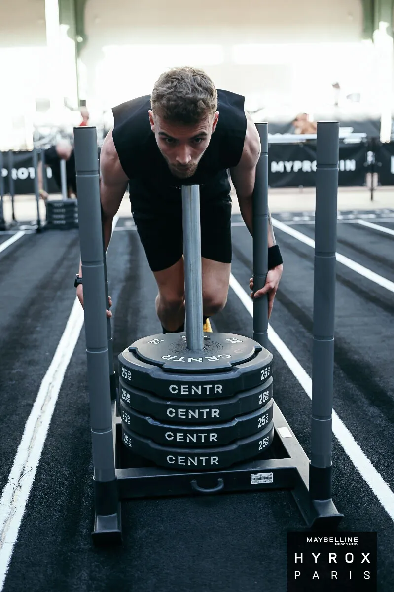 Jules, élève, poussant le traîneau lesté (sled push) à l'HYROX Paris